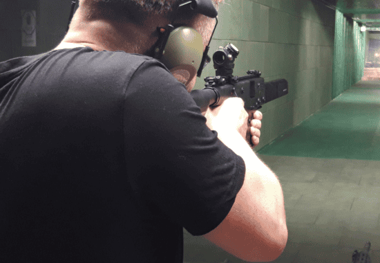 Guest aiming a rifle down the range, Krakow shooting range