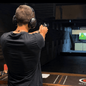 Guest aiming a handgun down the range, Krakow shooting range