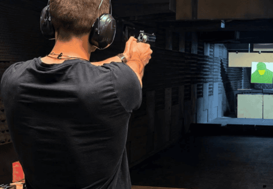 Guest aiming a handgun down the range, Krakow shooting range